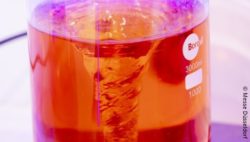 Image: Beaker with orange fluid; Copyright: Messe Düsseldorf