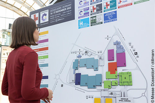 Image: Woman standing in front of a hall map; ©Messe Düsseldorf/ cTillmann