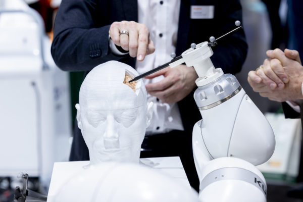Image: Robotic arm operates on brain model; Copyright: Messe Düsseldorf