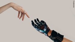 Image: A prosthetic hand and a human hand almost touch. Based on Michelangelo's 